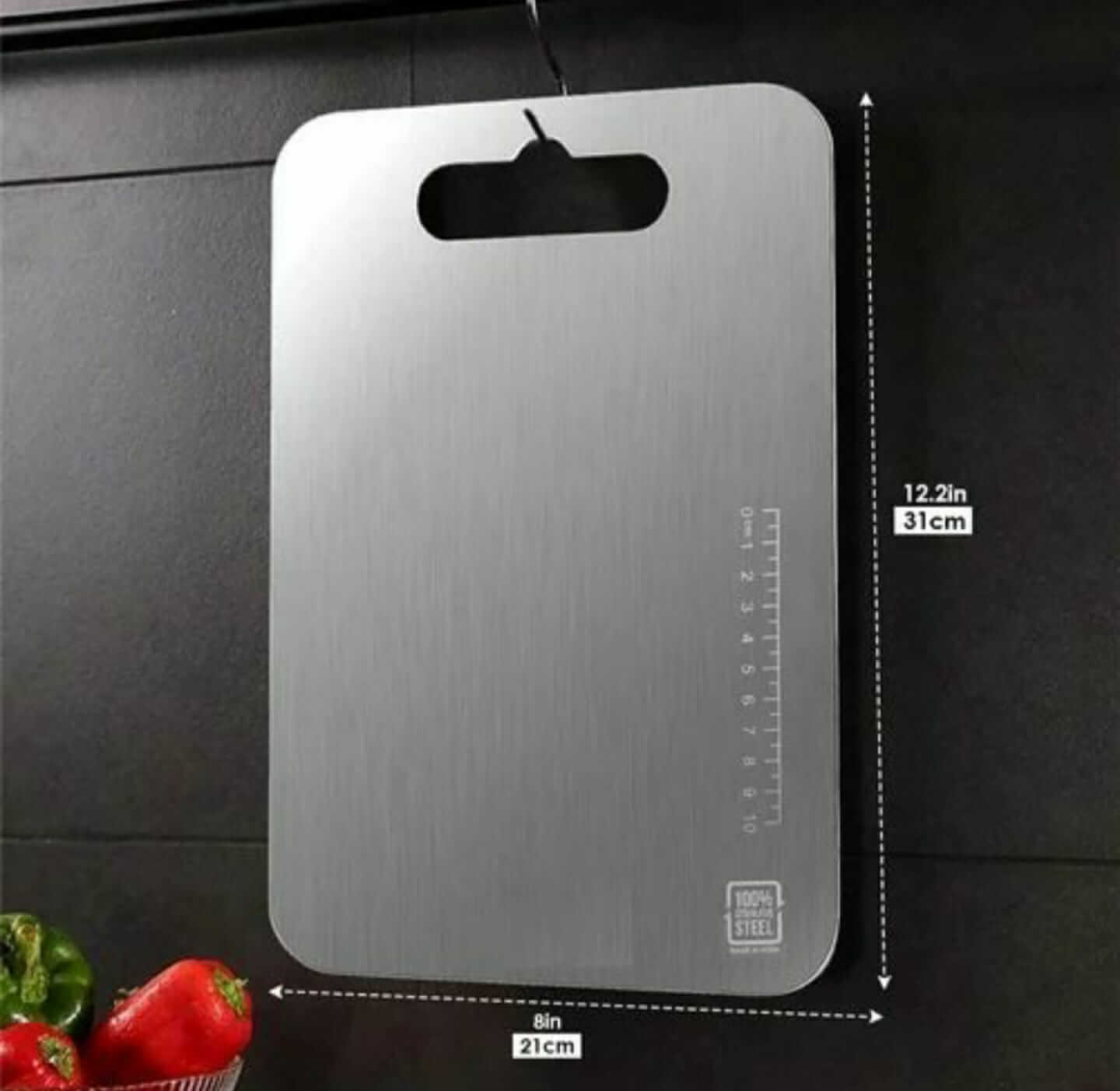 Stainless steel chopping board (31x21CM) hanging on a wall, rust-resistant and anti-bacterial for food prep.