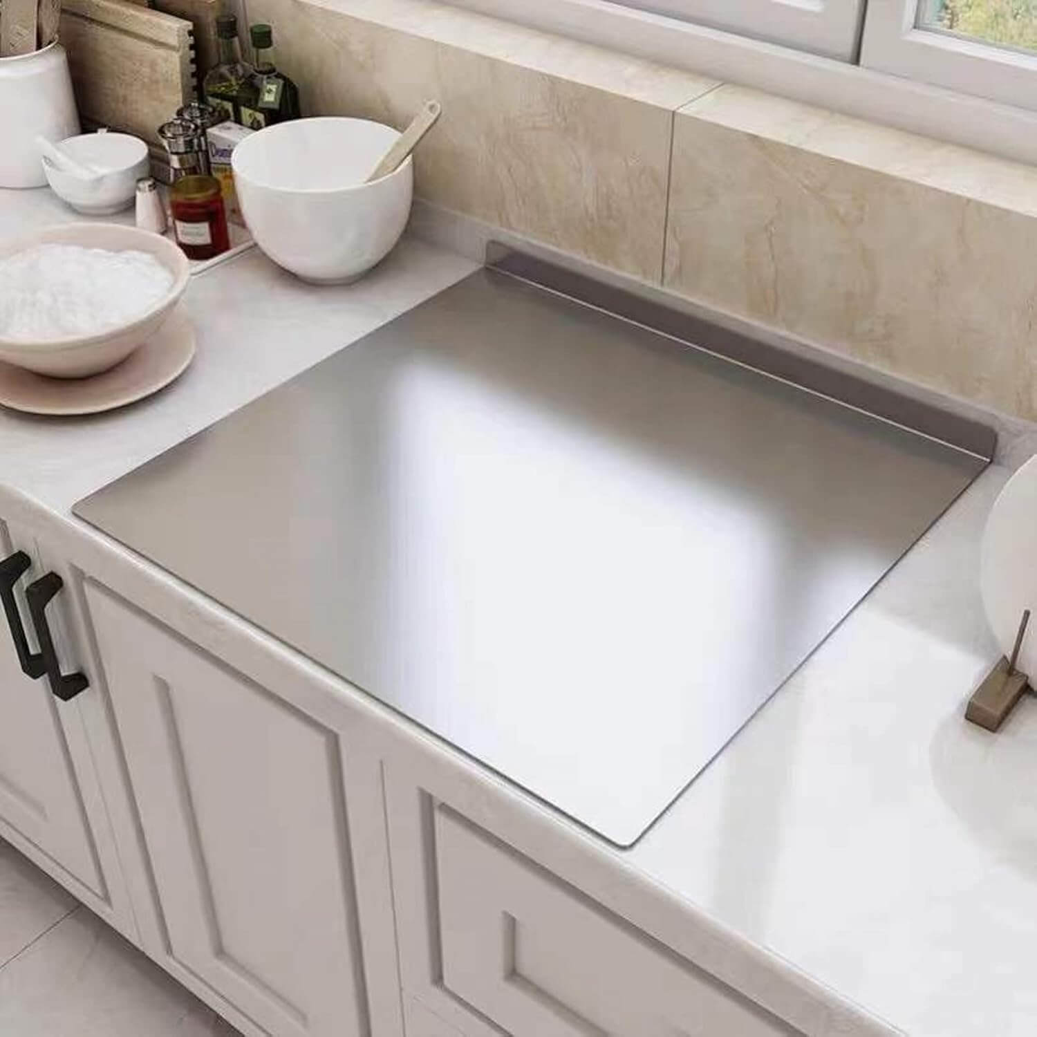 Stainless steel chopping board on a modern kitchen countertop, showcasing durability and hygiene for food preparation.