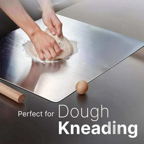 Hands kneading dough on a stainless steel surface, ideal for baking and food prep.